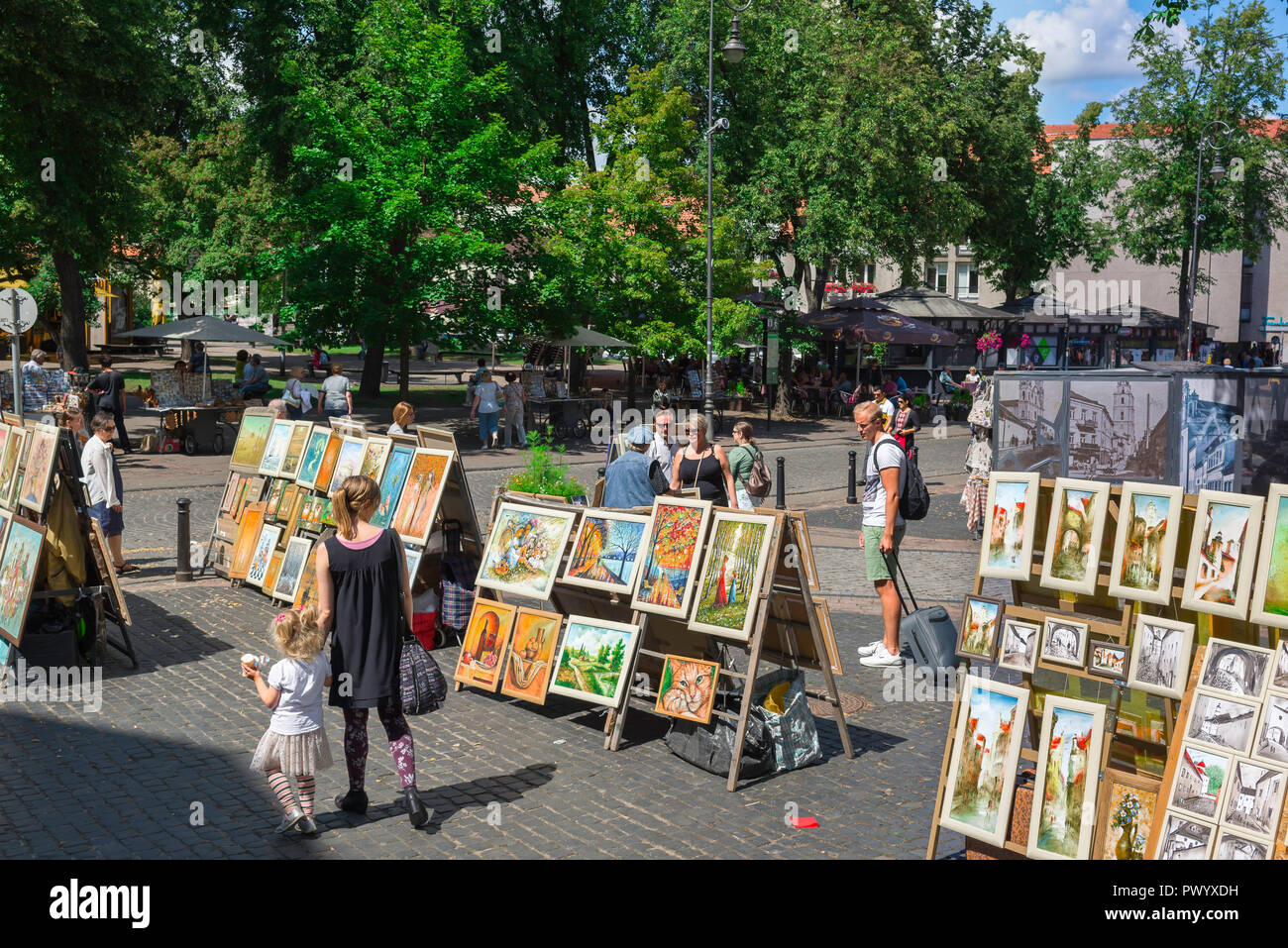 Kunst verkaufen Straße, Menschen in Vilnius Altstadt Schauen Sie sich eine Ausstellung von lokalen Künstlern Gemälde zum Verkauf, Vilnius, Litauen. Stockfoto