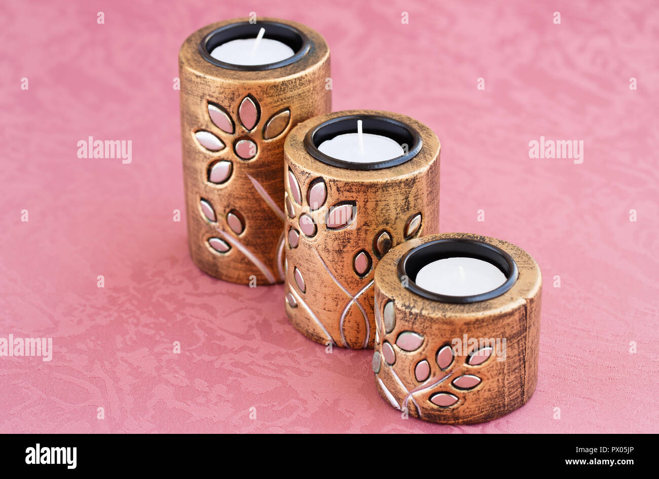 Drei braun alten Stil Kerze Nester auf Hintergrund Tuch. Stockfoto