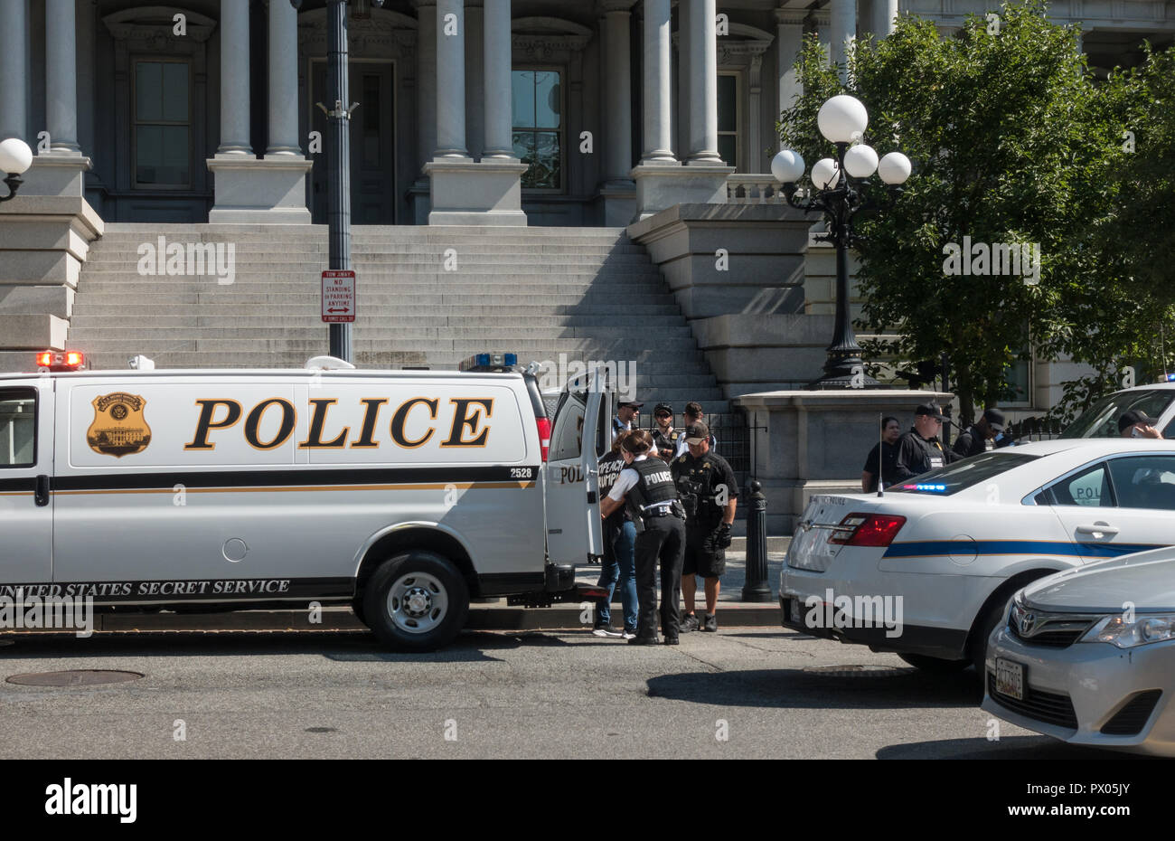 Polizei nimmt Demonstrator (mit Trumpf shirt Anzuklagen) während Kavanaugh Bestätigung Protest, 01.10.2018. Eisenhower Executive Office Gebäude, DC in bg. Stockfoto