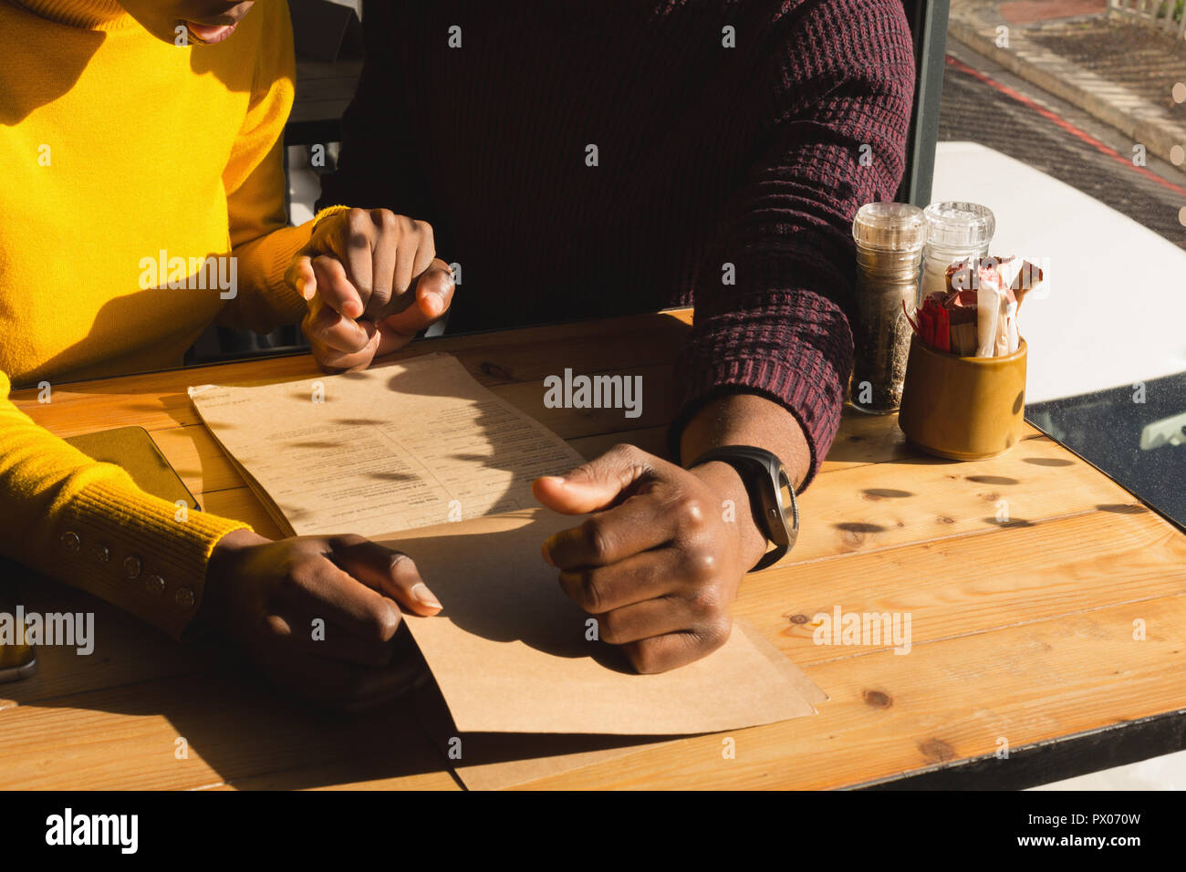 Paar an Menü im Café suchen Stockfoto