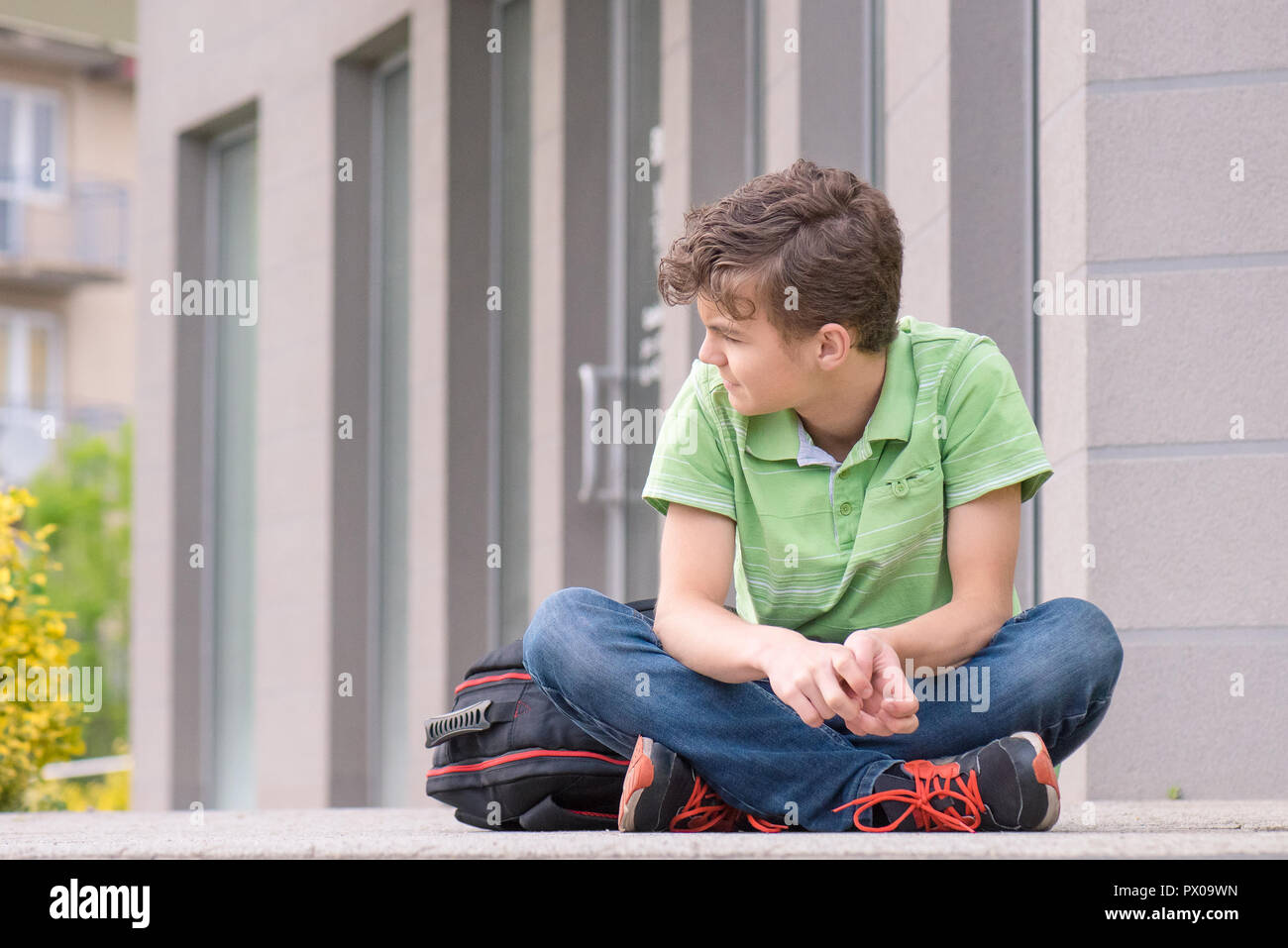 Outdoor Portrait von jugendlich Junge 14 Jahre alt mit Rucksack auf den ersten oder den letzten Schultag. Zurück in die Schule nach dem Urlaub. Stockfoto