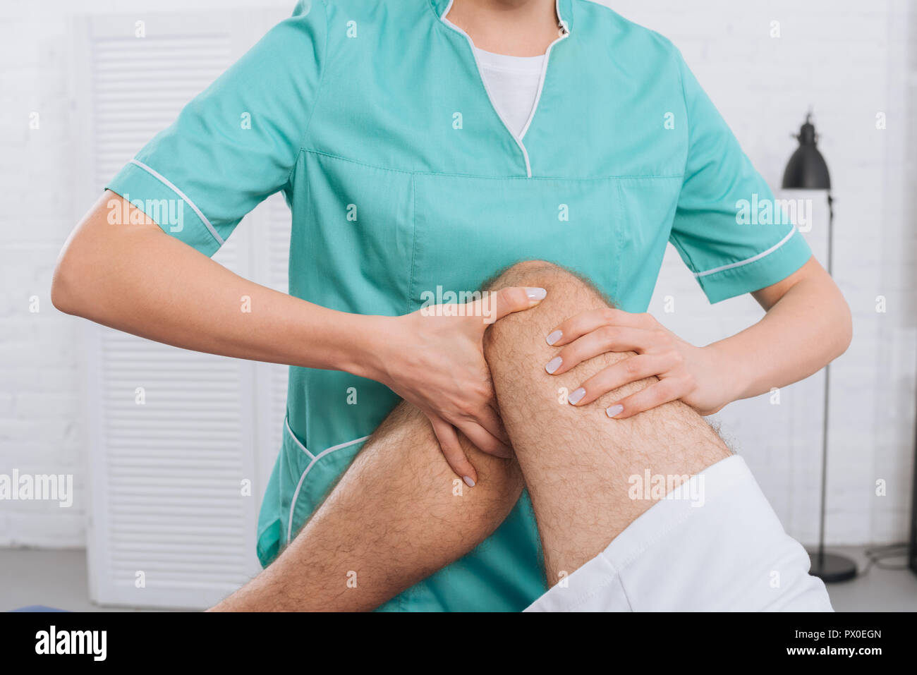 7/8 Schuß von Massage Therapeut tun Bein Massage an Patienten in der Klinik Stockfoto
