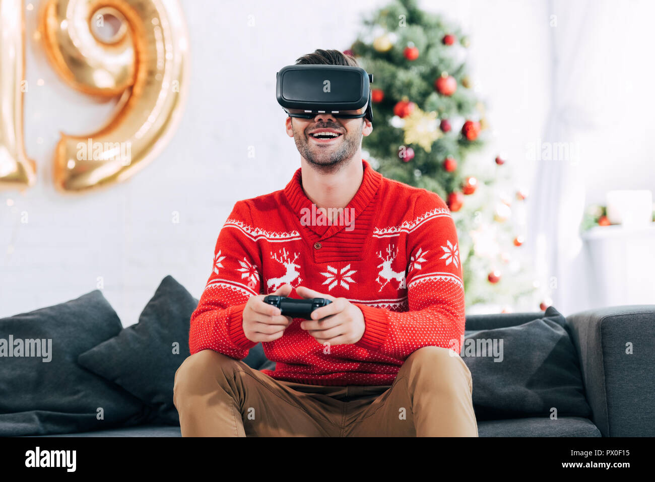 Glückliche Menschen mit Virtual reality Headset und Freude Pad spielen video Spiel während 2019 neues Jahr Stockfoto