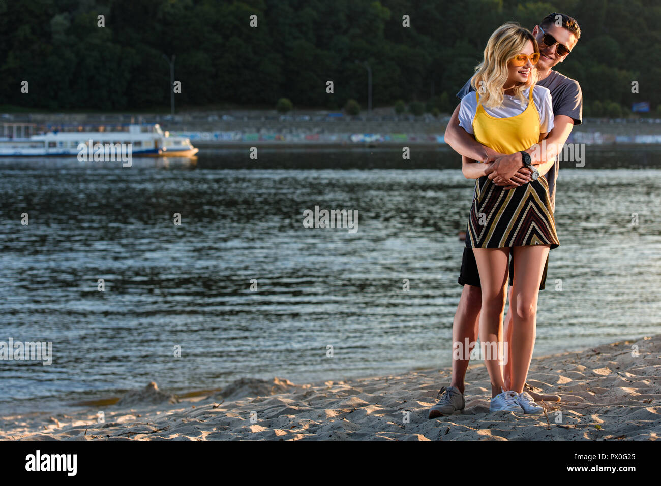 Freund kuscheln Freundin am Strand am Fluss Stockfoto