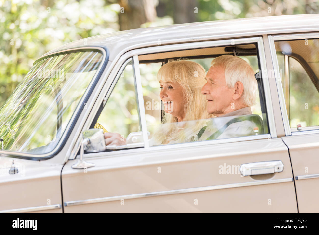 Seitenansicht der älteren Mann und Frau beige Auto fahren Stockfoto