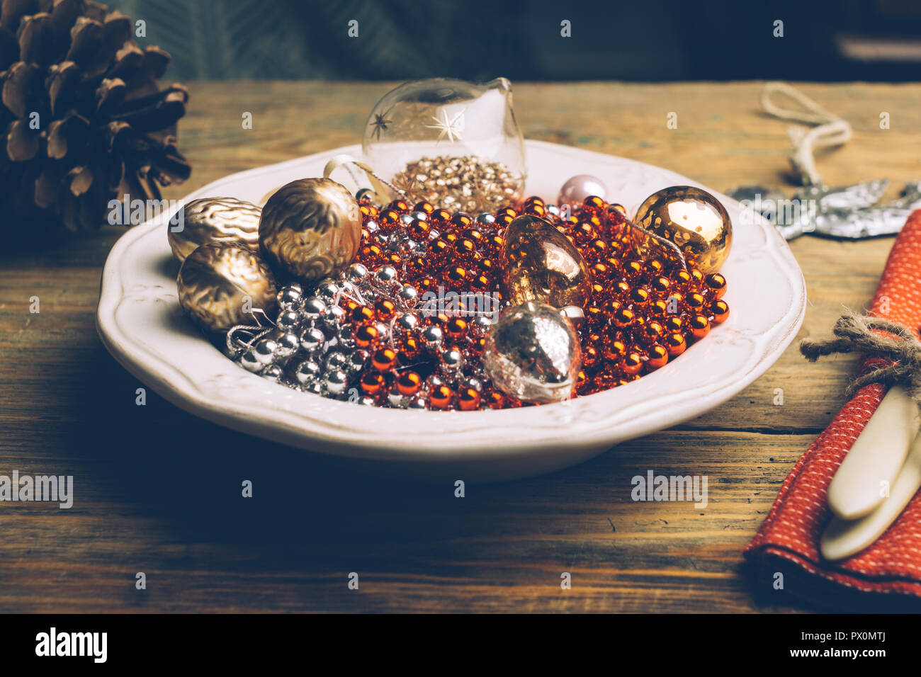 Urlaub Weihnachten Lebensmittel Hintergrund Konzept. Weihnachten Tabelle mit einer weißen Platte und Weihnachtsschmuck. Besteck Messer und Gabel auf einem roten Serviette Stockfoto