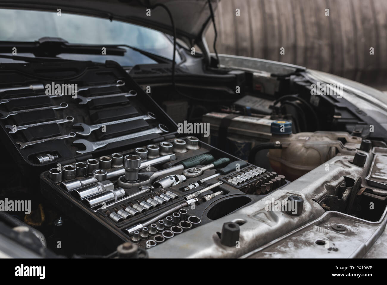 Gebrochene Auto mit offener Haube auf Straße, Box mit Tools Stockfoto