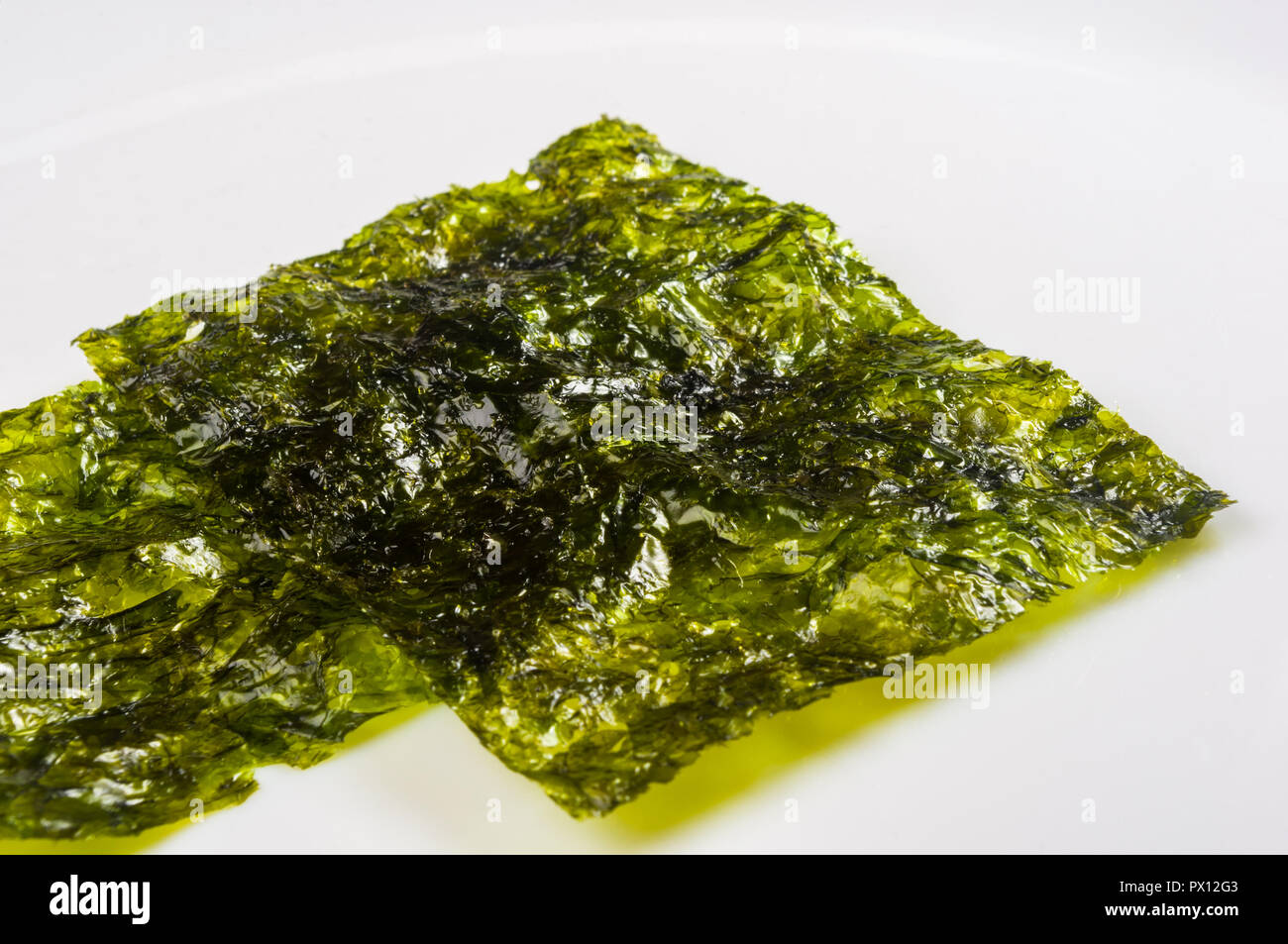 Nori Chips auf einem weißen Keramikplatte, Algen, Blätter, Makro, Nahaufnahme, Textur Stockfoto