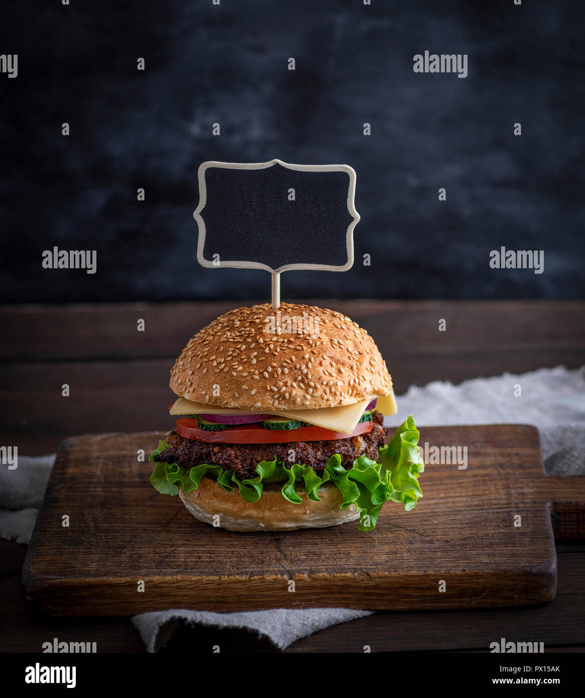 Hamburger mit Fleisch Patty und frisches Gemüse, eine leere Holz- Wegweiser nach oben einstellen Stockfoto