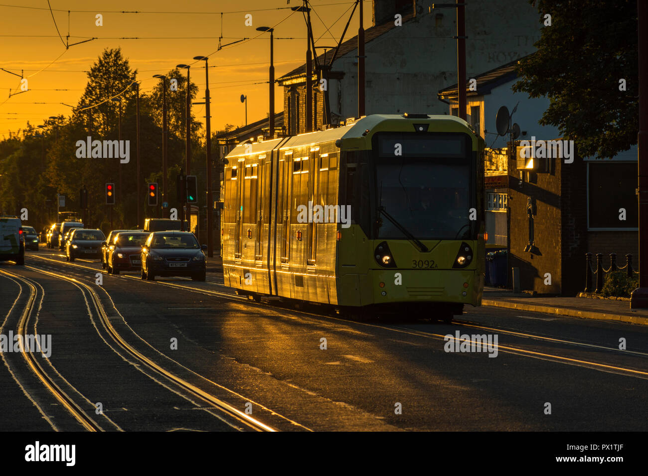 Metrolink Tram und Titel auf Manchester Road, Droylsden im Abendlicht, Tameside, Manchester, England, Großbritannien Stockfoto