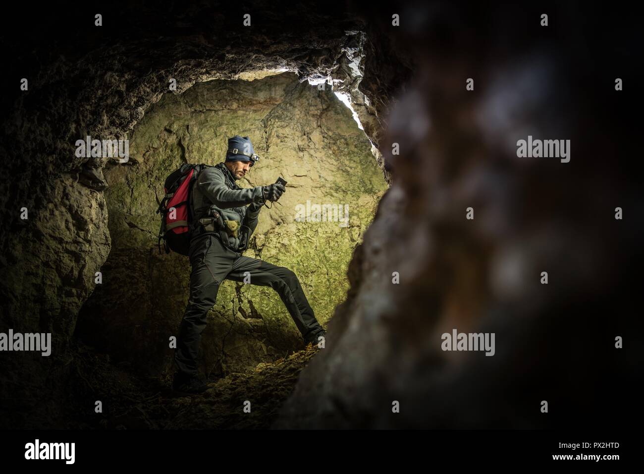 Tiefen Höhle Exploration von Männern mit Taschenlampen und Rucksack. Kaukasische Höhlenforscher in der Grotte. Stockfoto