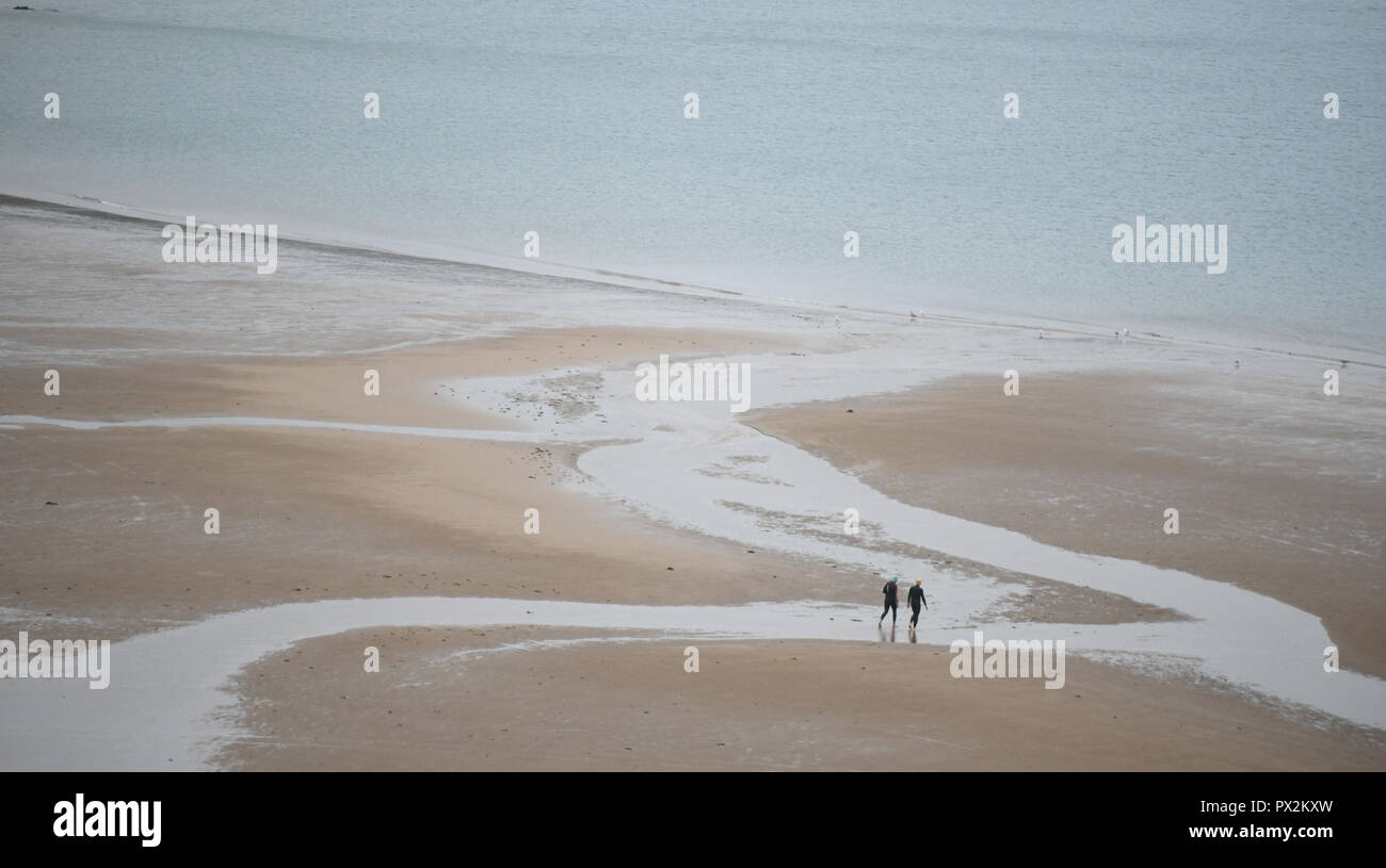 Zwei Zahlen entlang einer leeren Sandstrand in Richtung Meer. Stockfoto