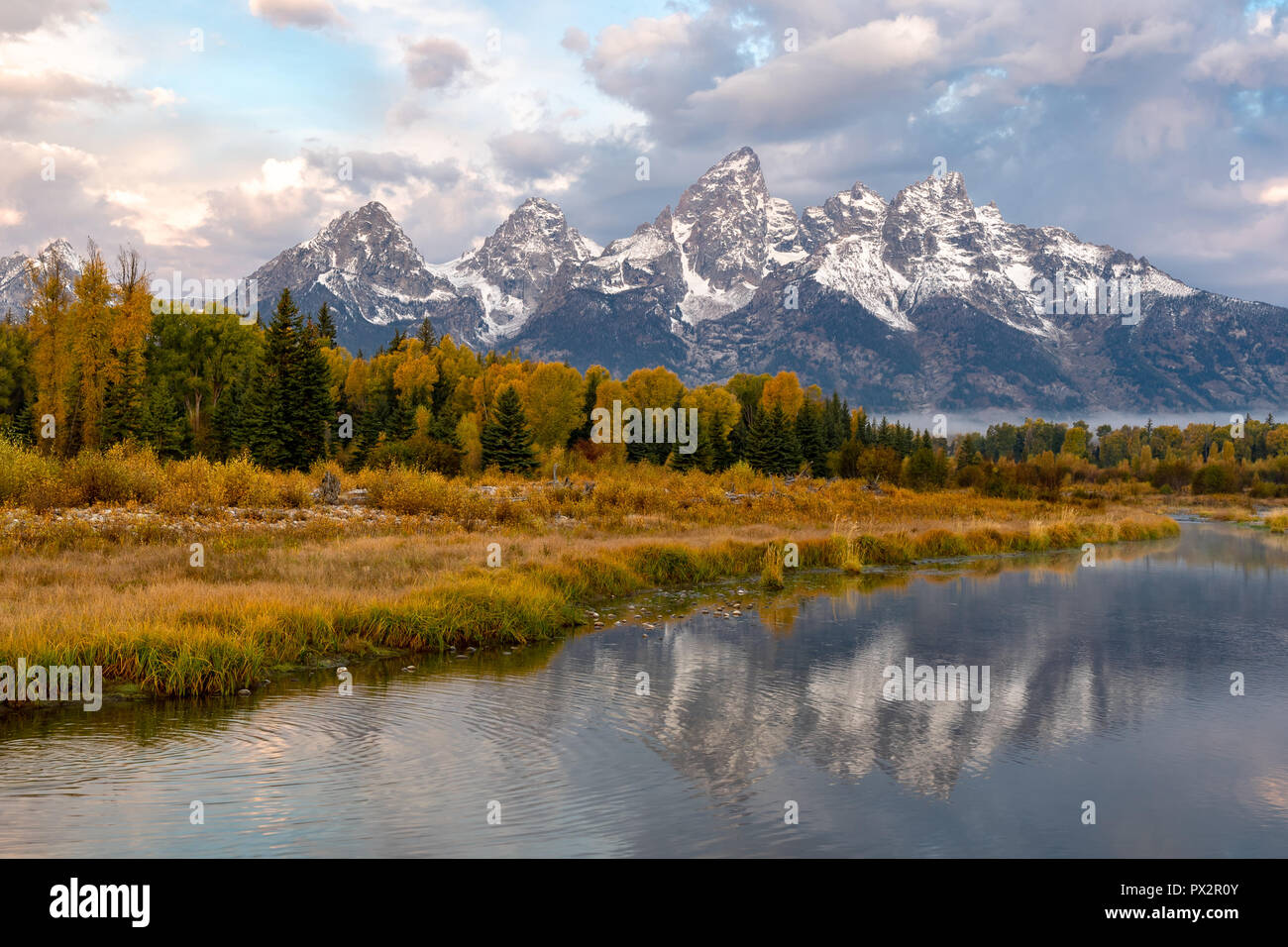 Die schneebedeckten Berge sind in den frühen Morgenstunden Snake River im Grand Teton National Park wider Stockfoto