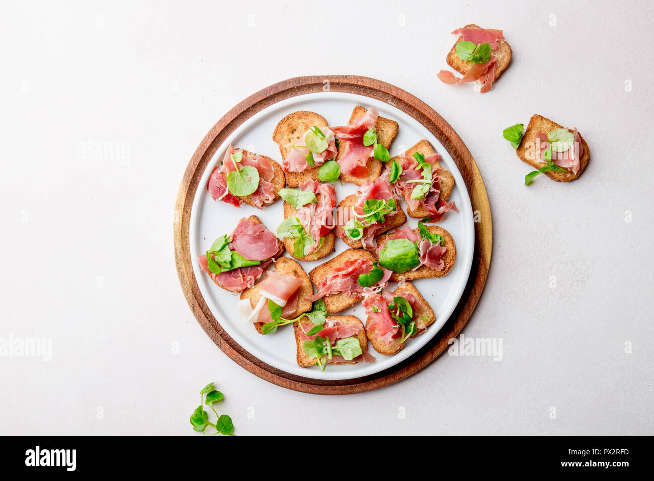 Mini offene Sandwiches mit Jamon Serrano auf weiße Platte. Stockfoto