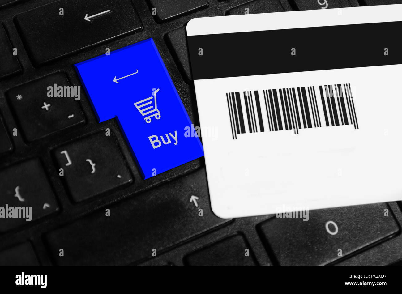 Online shopping Konzept, Warenkorb auf der Tastatur eines Laptops, Kreditkarte auf der Tastatur eines Laptops. Stockfoto