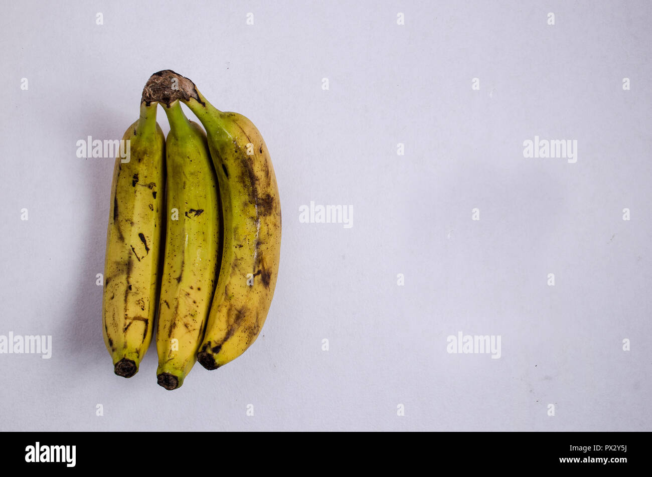 Gruppe von drei reife Bananen, auf einem isolierten weißen Hintergrund, Schuß von oben genommen. Stockfoto