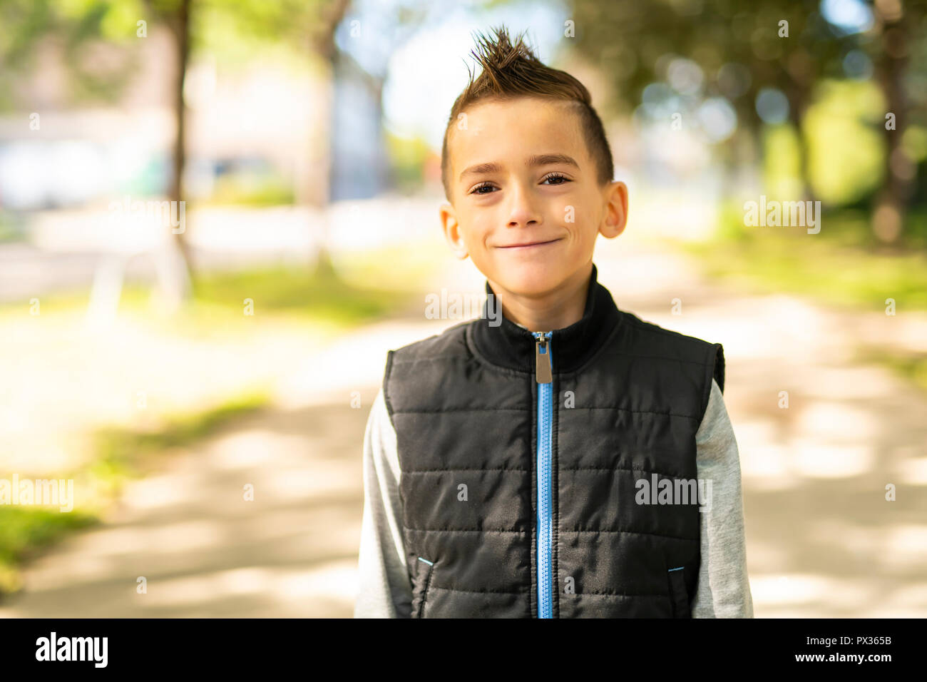 Ein netter Junge außerhalb als Modell posiert Stockfoto