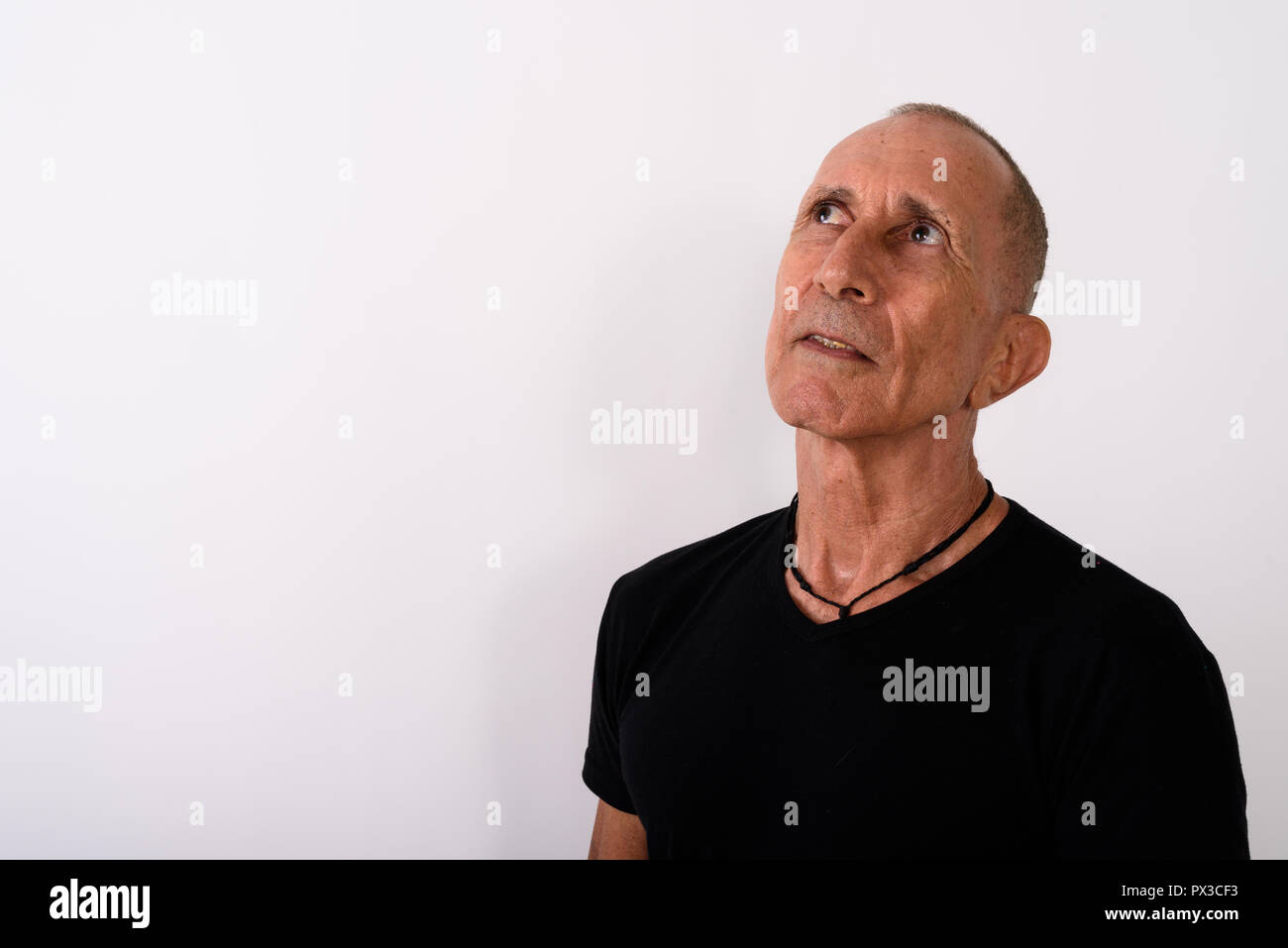 Studio shot der kahlen älterer Mann denken, während auf der Suche Stockfoto