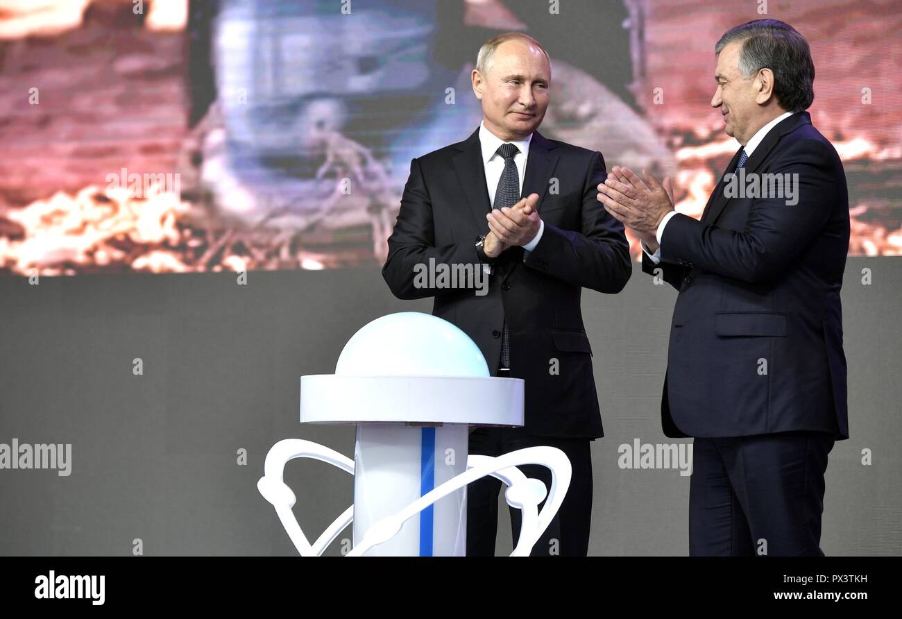 Der russische Präsident Wladimir Putin, Links, und der usbekische Präsident Shavkat Mirziyoyev, Klatschen nach der Einführung des Kernkraftwerk KKW Novovoronezhskaya-2 Oktober 19, 2018 in Taschkent, Usbekistan. Das Projekt in Navoiy wird das erste Kernkraftwerk in dem zentralasiatischen Land zu einem Preis von $ 11 Milliarden Dollar verursachen. Stockfoto