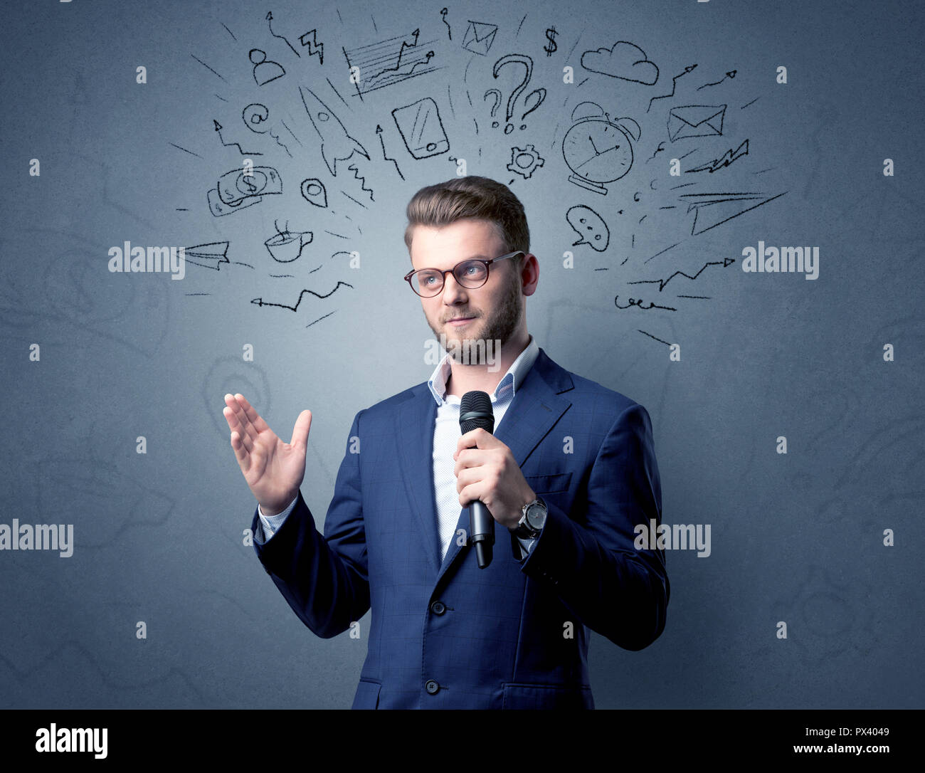 Geschäftsmann sprechen in das Mikrofon mit gemischten Doodles über seinem Kopf Stockfoto