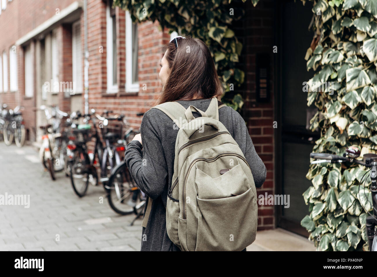 Touristen mit einem Rucksack ist auf der Suche nach online buchen Unterkünfte in einer fremden Stadt. Oder ein Schüler Mädchen mit einem Rucksack ist ein Spaziergang durch die Stadt. Stockfoto