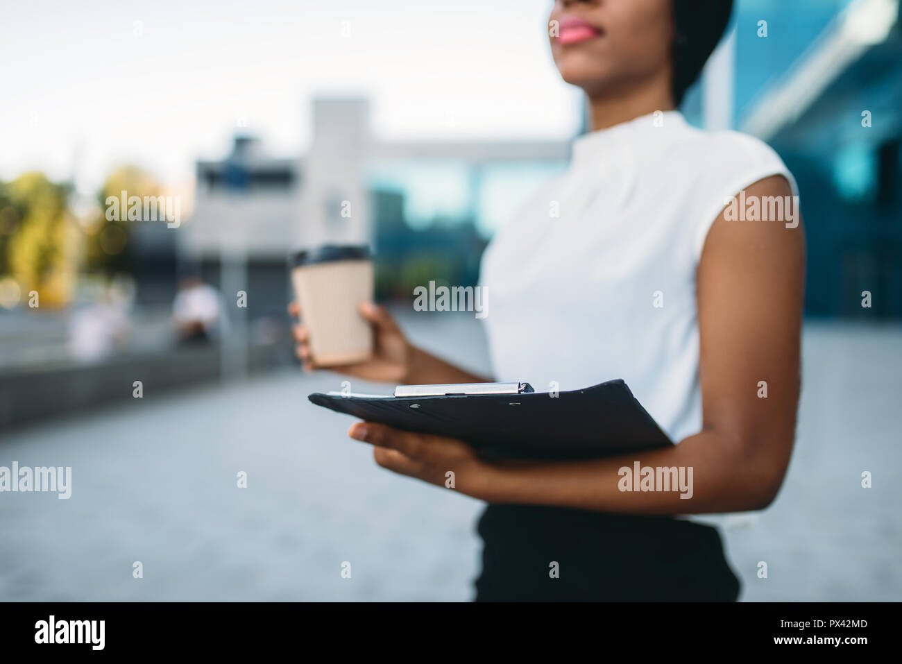 Weibliche business Person mit Kaffeetasse und Notepad Stockfoto