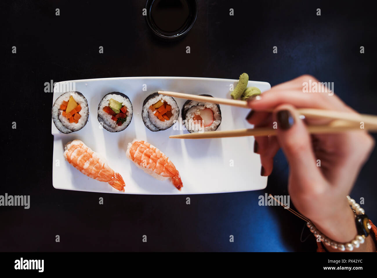 Nahaufnahme eines Sushi Platte mit weiblicher Hand mit Stäbchen Stockfoto