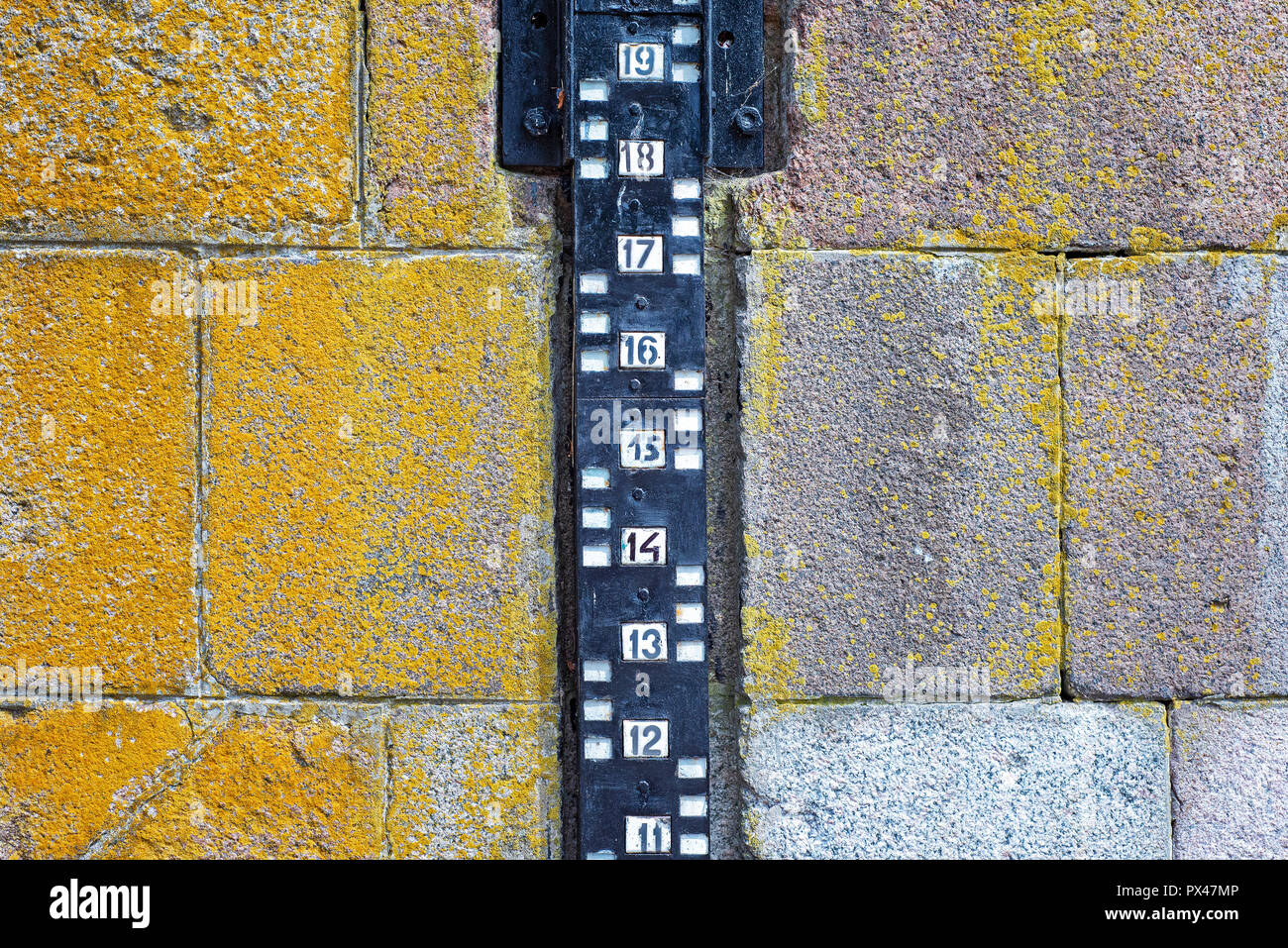 Pegelmessung an die Mauer aus Stein in der Nähe des Flusses befestigen Stockfoto