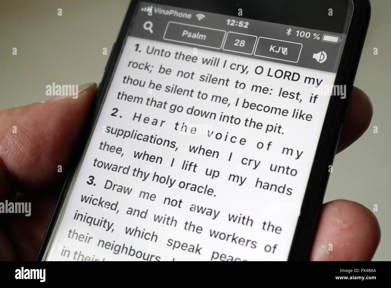 Bibel auf einem Smartphone. Mann Lesen des Neuen Testaments. Die psalmen. Stockfoto