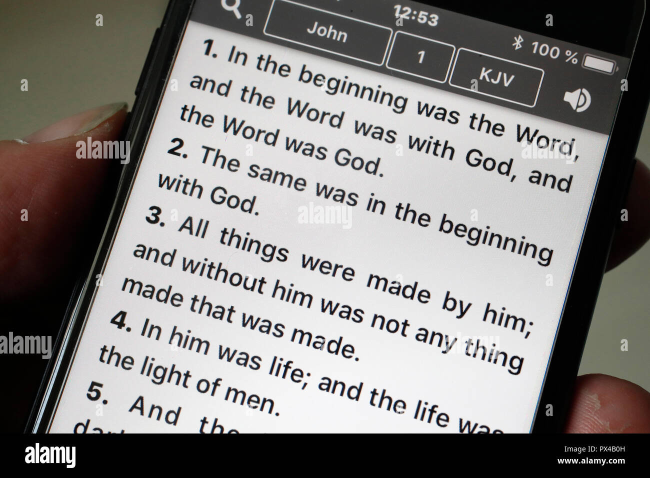 Bibel auf einem Smartphone. Mann Lesen des Neuen Testaments. Evangelium nach Johannes. Stockfoto