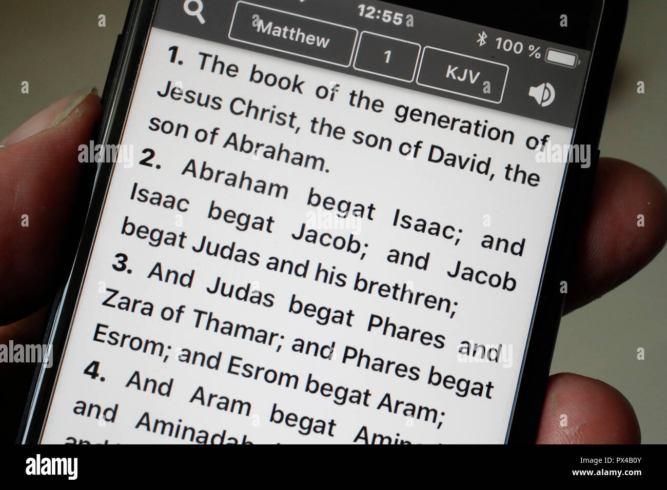 Bibel auf einem Smartphone. Mann Lesen des Neuen Testaments. Evangelium nach Matthäus. Stockfoto