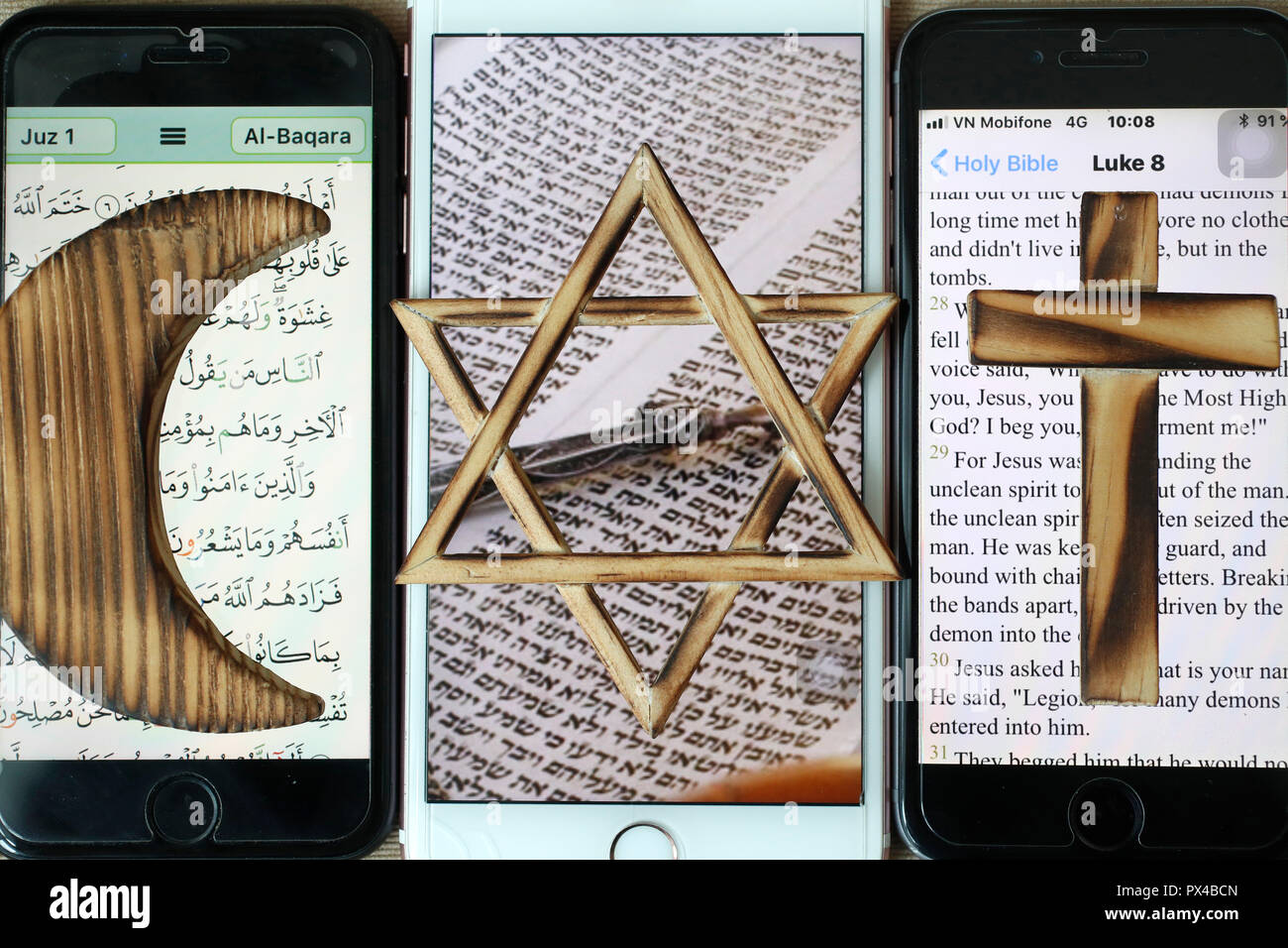 Jüdische, christliche und muslimische Kreuz und Halbmond, religiöse Symbole von Christentum, Islam, Judentum auf 3 Smartphones mit digitalen App. Stockfoto