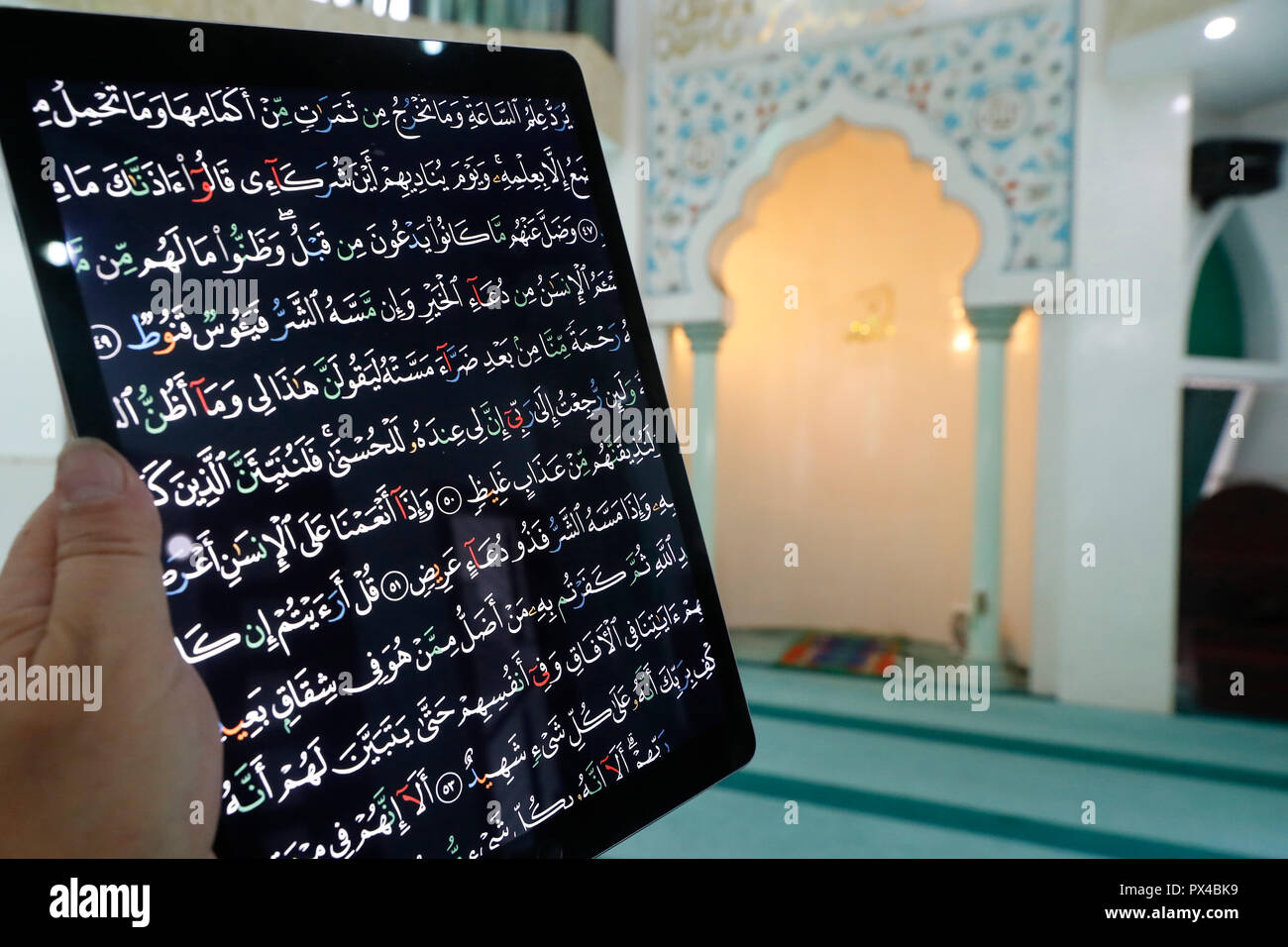 Mann Auslesen von elektronischen Quran auf einem Ipad. Stockfoto