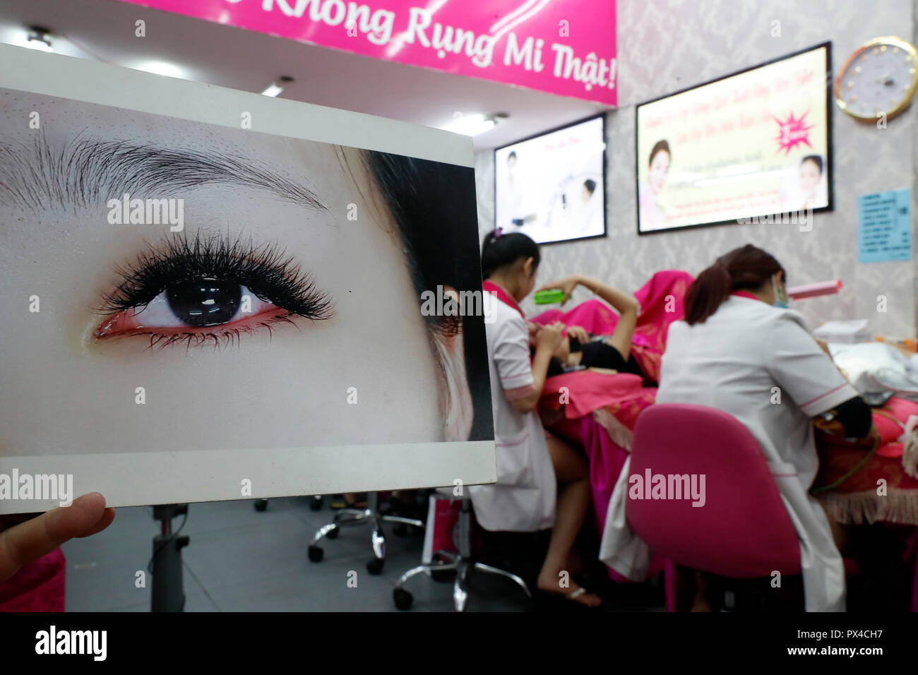 Vietnamesische Beauty Salon. Kosmetikerin Anwendung verlängert die Wimpern zu Frau. Ho Chi Minh City. Vietnam. Stockfoto