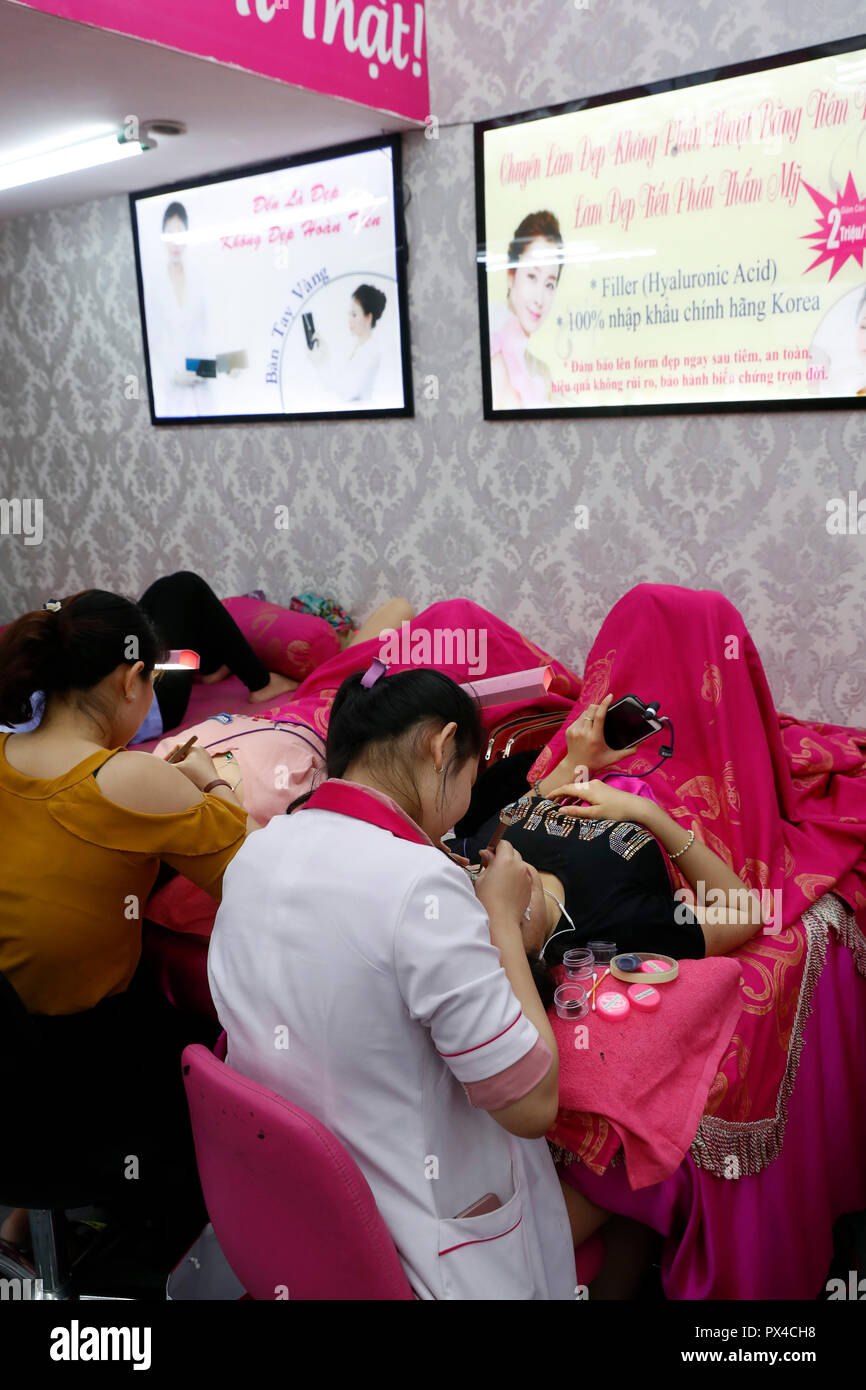 Vietnamesische Beauty Salon. Kosmetikerin Anwendung verlängert die Wimpern zu Frau. Ho Chi Minh City. Vietnam. Stockfoto