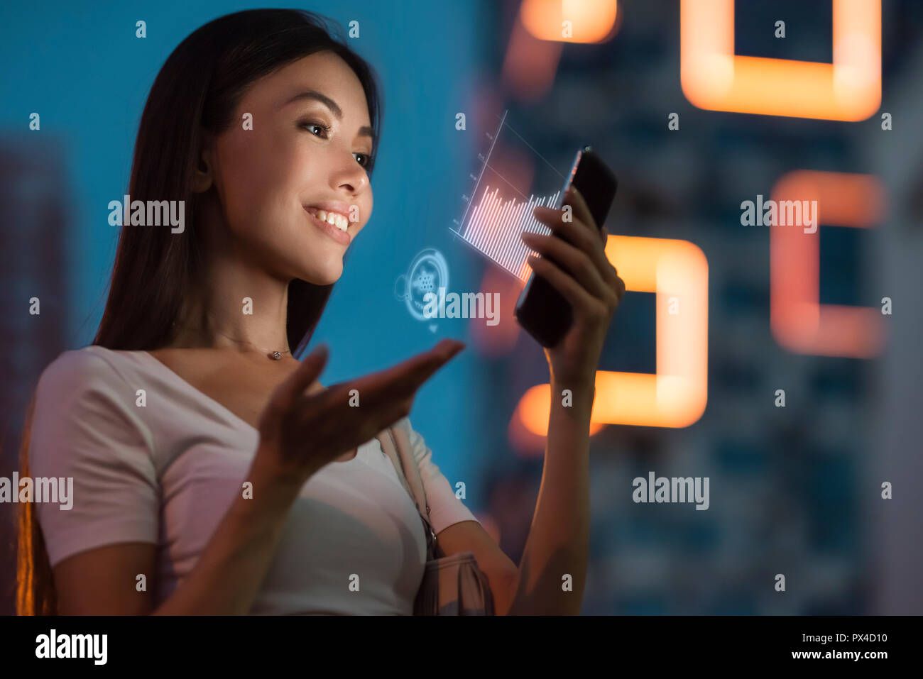 Eine junge schöne asiatische Frau mit Hilfe von innovativen Technologien als Anwendung in Ihrem Smart Phone sales Analytics zu überwachen. Stockfoto