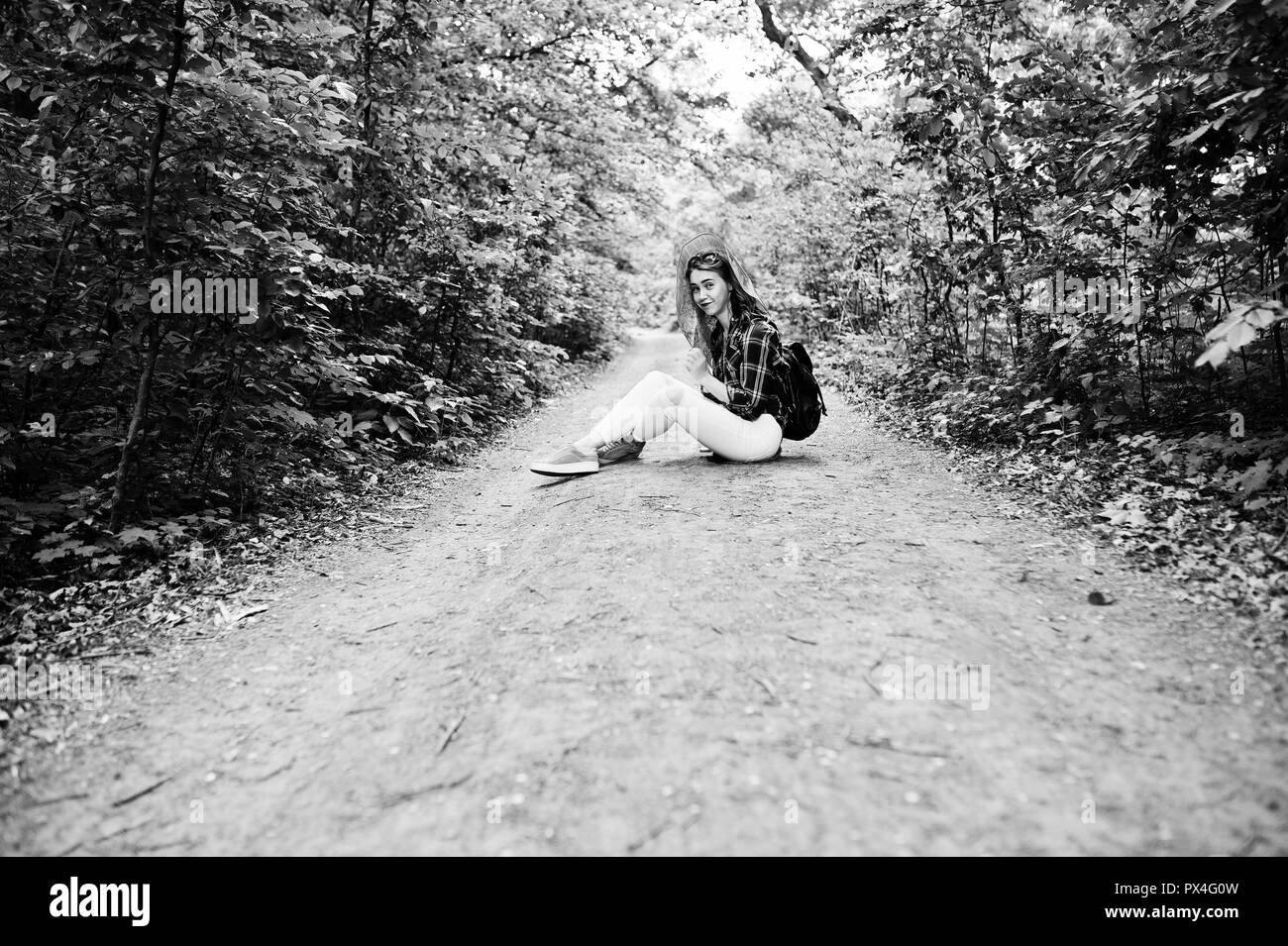 Porträt einer positiven junge wunderschöne Blondine auf dem Boden sitzend mit einer Karte in den Händen in den Wald. Stockfoto