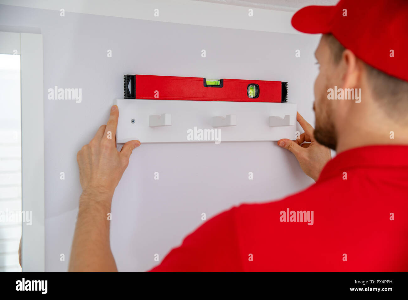 Handyman Services - Mann installation Handtuchhalter an der Wand Stockfoto
