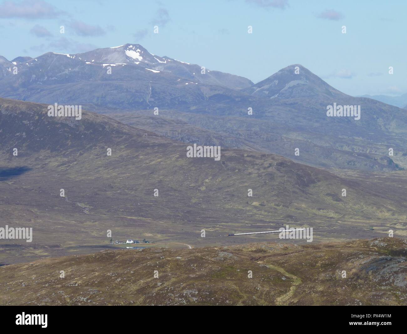 Den Zug um corrour Halt mit dem Grey Corries im Hintergrund, Schottland Stockfoto