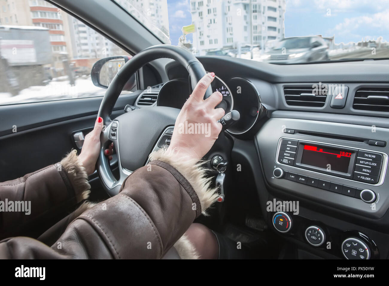 Weibliche Hände am Lenkrad des Autos im Winter Stockfoto