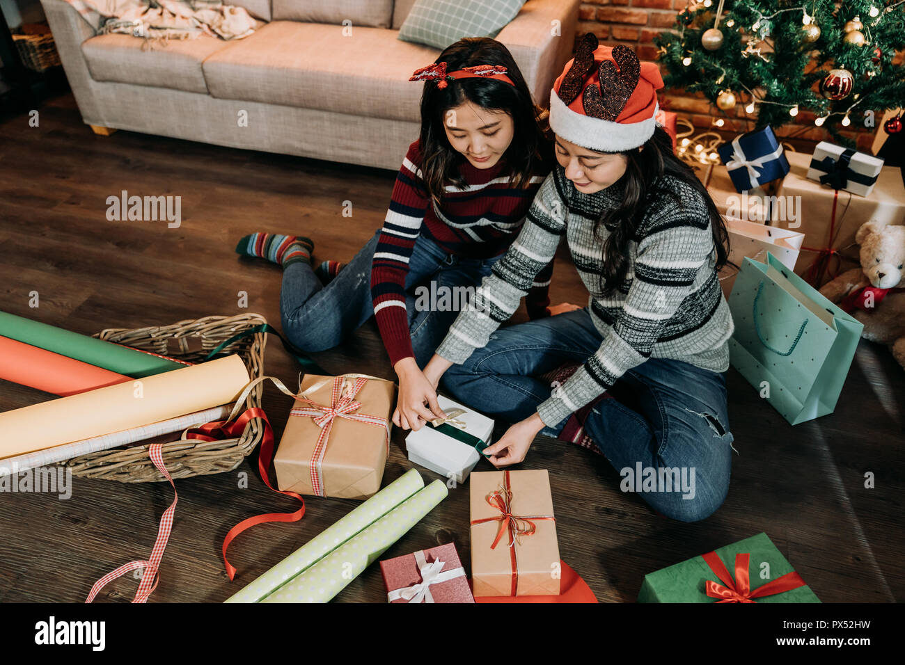 Die Mädchen bereiten präsentiert für das kommende neue Jahr und Weihnachten. Junge Damen Artwork zu Hause. Der Ribbon auf der Box als Weihnachtsgeschenk am zweiten Weihnachtstag binden. Stockfoto