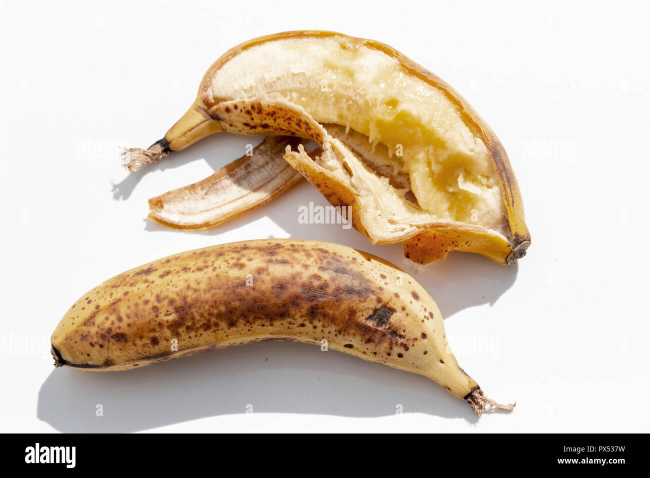 Eine Nahaufnahme von zwei reife, gelbe Bananen, geknallt hat Abd auf der einen Seite nebeneinander auf einem isolierten weißen Hintergrund geöffnet Stockfoto