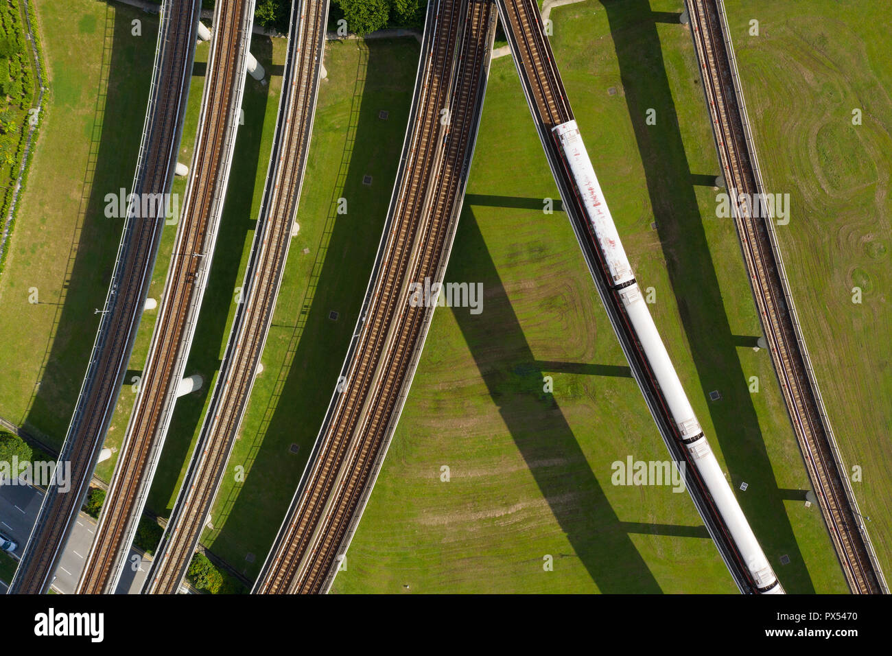 Luftaufnahme eines öffentlichen Zuges, der auf einem Gleis fährt. Singapur. Stockfoto