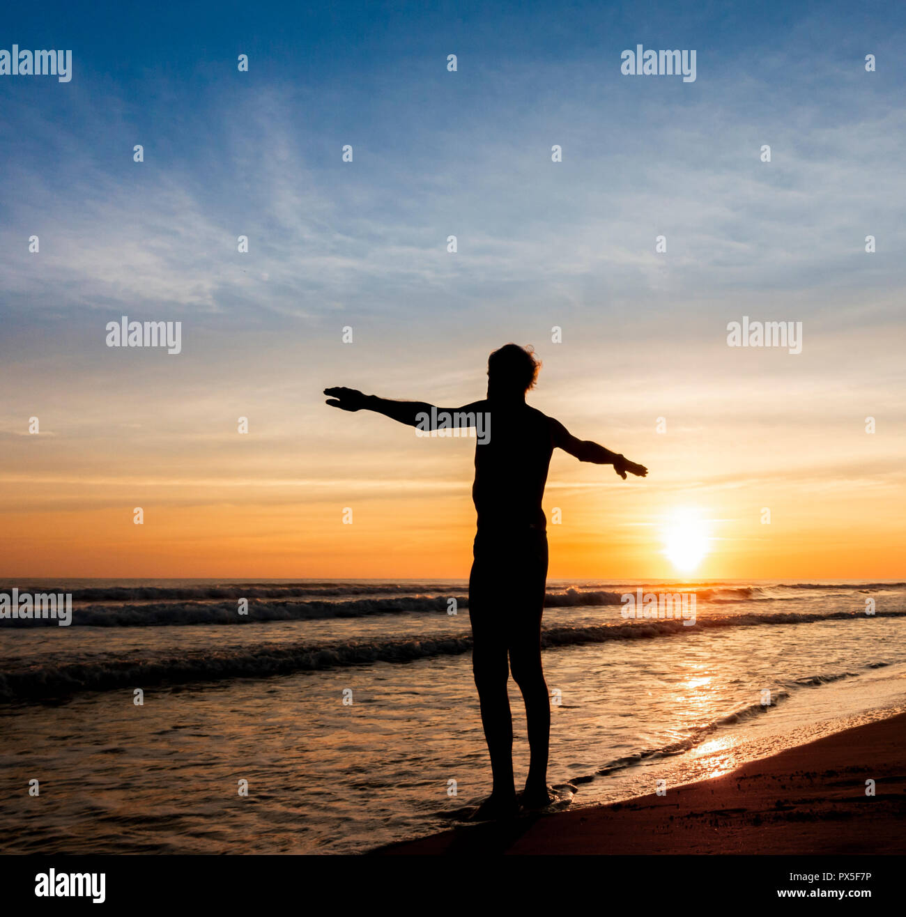 Älterer mann Strecken, bevor am Strand bei Sonnenaufgang schwimmen. Stockfoto