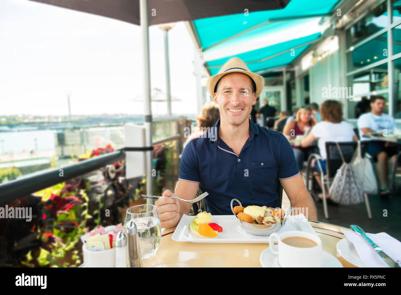 Ein junger Mann, der Touristen für das Frühstück mit Kaffee sitzen Stockfoto