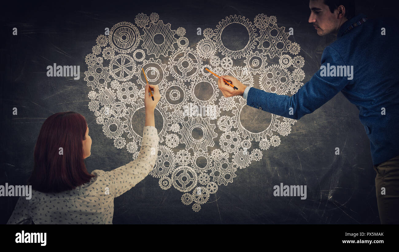Mann und Frau Gedanken zu einem großen cog Herz auf der Tafel. Menschen Liebe und Gefühle, Partnerschaft und Teamarbeit Konzept. Stockfoto