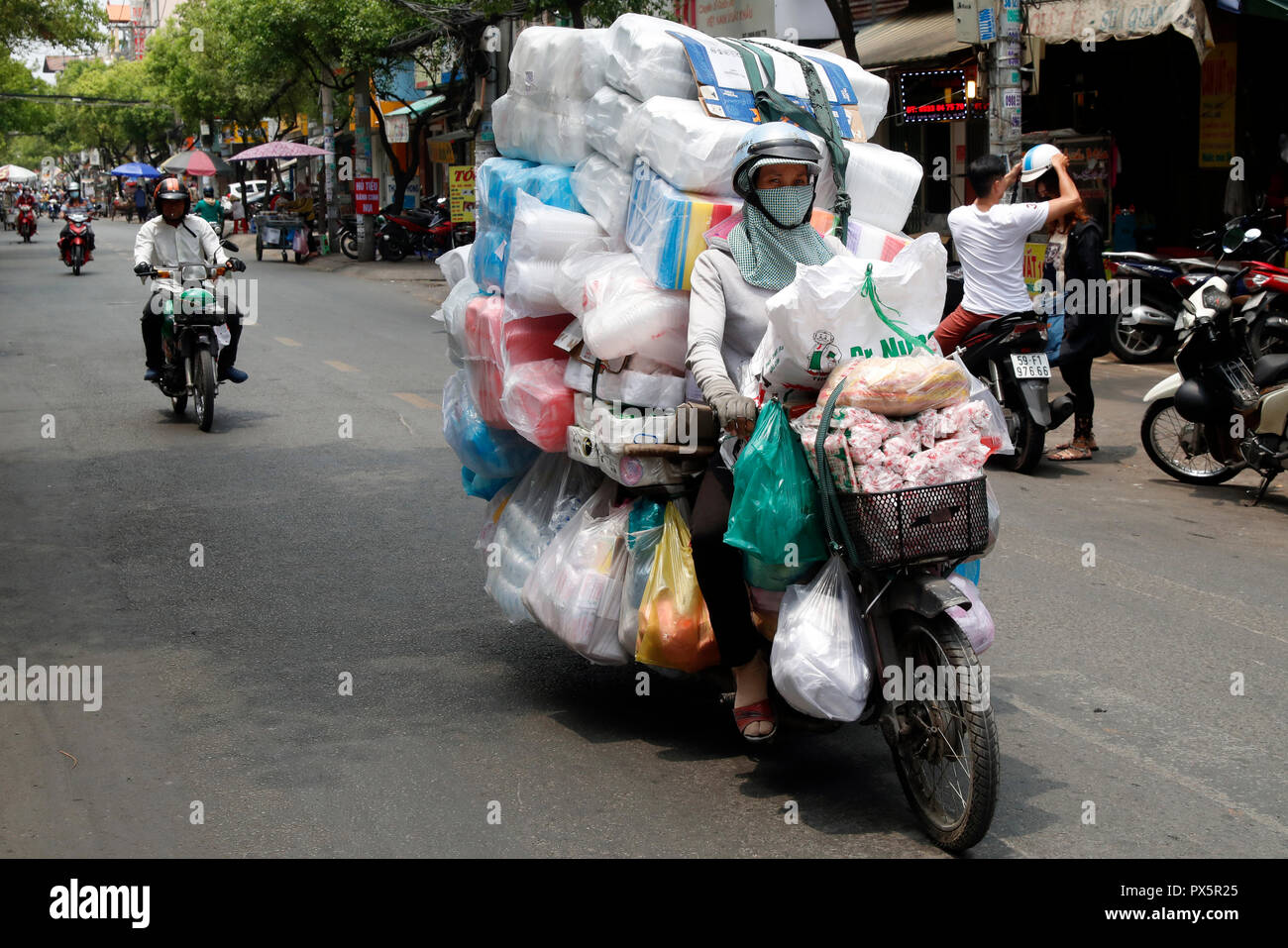 Frau, die ein Motorrad mit großen kostenlos auf Saigon Straße. Ho Chi Minh City. Vietnam. Stockfoto