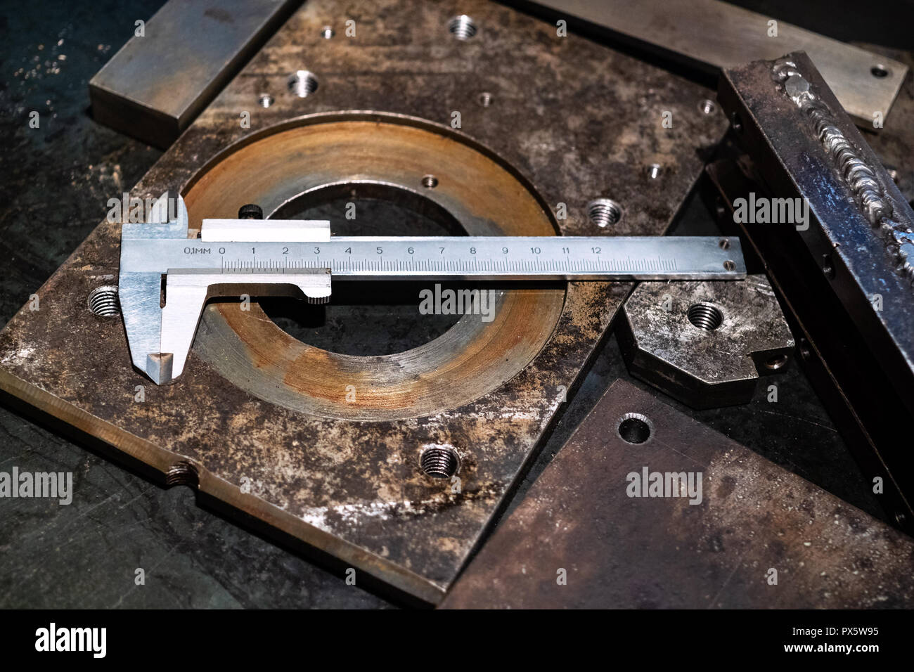 Immer noch leben - Metallbearbeitung Stahl Bremssättel auf Metall Werkbank in der Drechslerei Workshop in kalten, blauen Licht, Stockfoto
