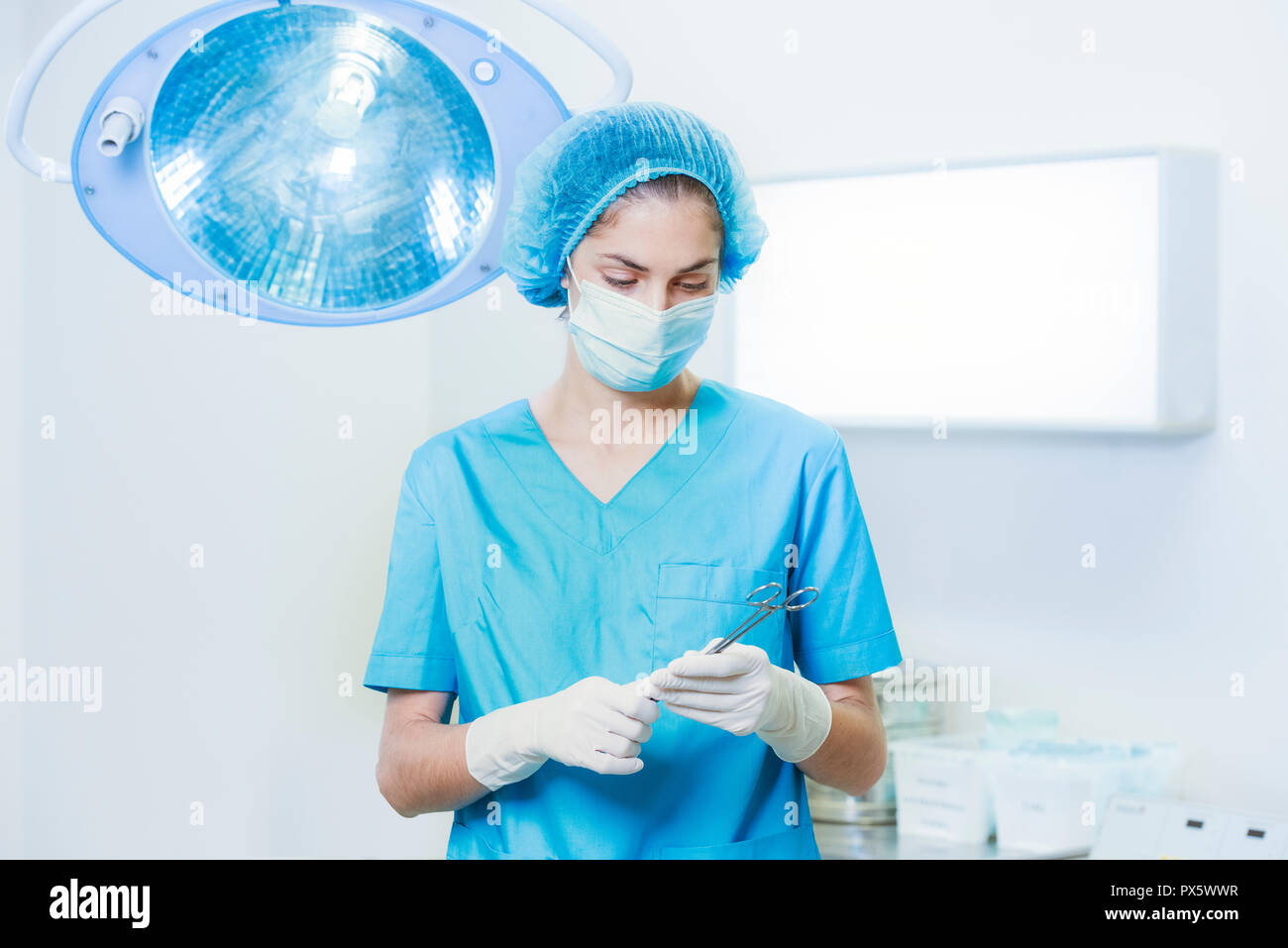 Frau Arzt oder Krankenschwester in der Chirurgie Outfit ist eine chirurgische Nadel in einem Operationssaal Stockfoto