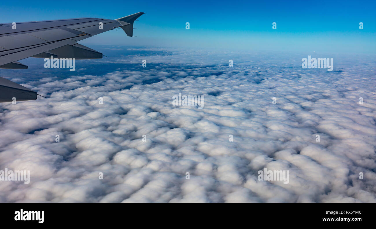 Blauer Himmel mit Wolken. Luftbild von oben aus dem Flugzeug Fenster. Stockfoto